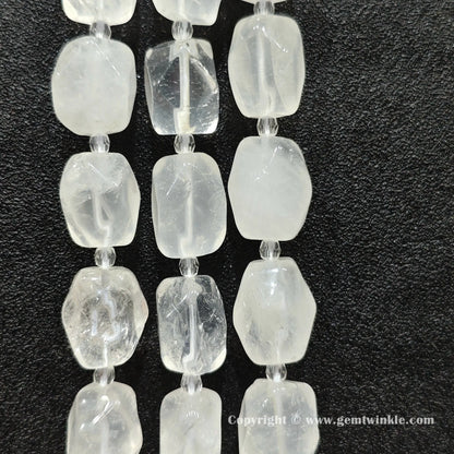 multiple strands of frosty clear quartz faceted barrel beads on dark texture
