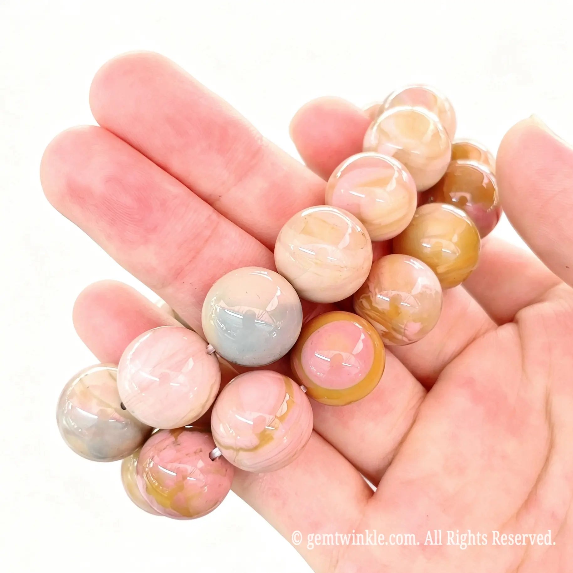 Handheld side angle view of stacked Alashan crackle agate bead stretch bracelets highlighting smooth glossy surface