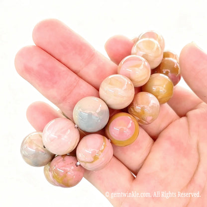 Handheld side angle view of stacked Alashan crackle agate bead stretch bracelets highlighting smooth glossy surface