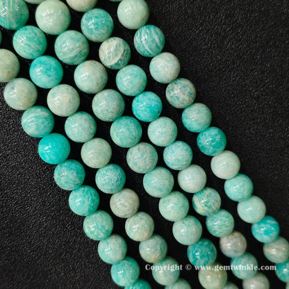 Row view of natural Grade C amazonite bead strands displaying teal tones with organic yellowish patches
