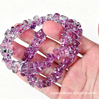 High clarity natural amethyst freeform pebble stretch bracelets resting on fingers showing vivid purple color and smooth edges