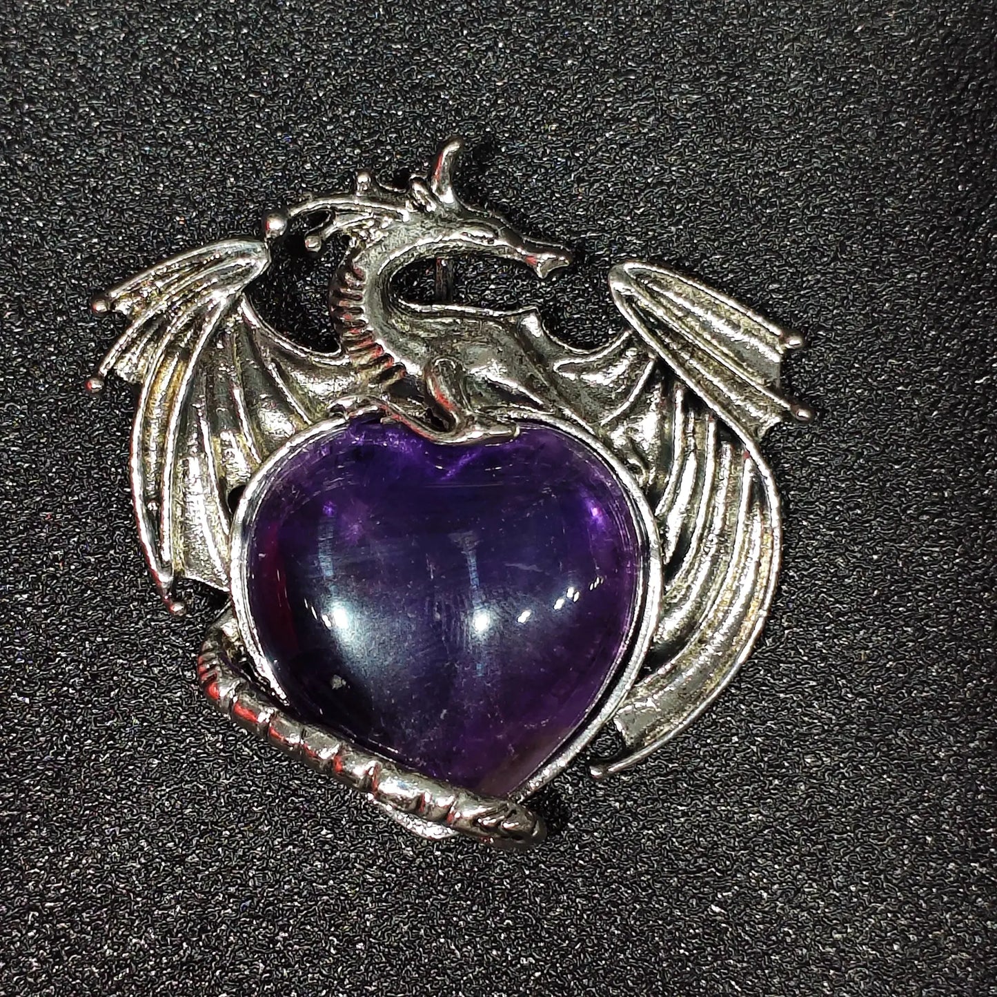 Antique pewter-tone metal alloy dragon wrapped around natural amethyst heart showing dense ice inclusions