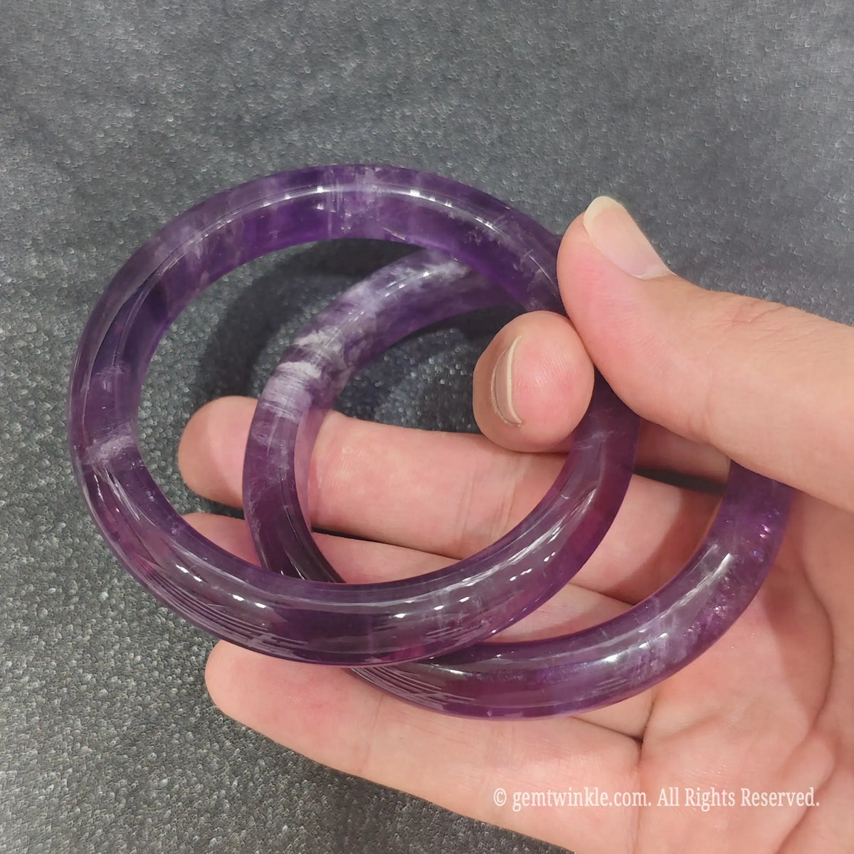 Pair of authentic carved Amethyst gemstone bangles showing natural violet crystal clarity