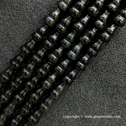 Angled view of natural black obsidian calabash cut gemstone strands