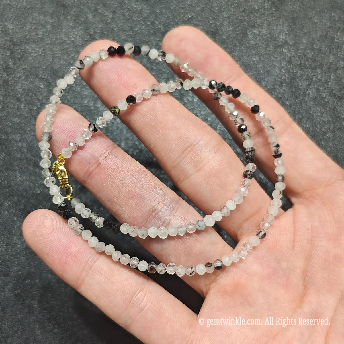Detailed macro view of 3mm micro faceted black rutilated quartz beads showing misty grey matrix and black rutile strands
