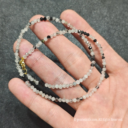 Detailed macro view of 3mm micro faceted black rutilated quartz beads showing misty grey matrix and black rutile strands