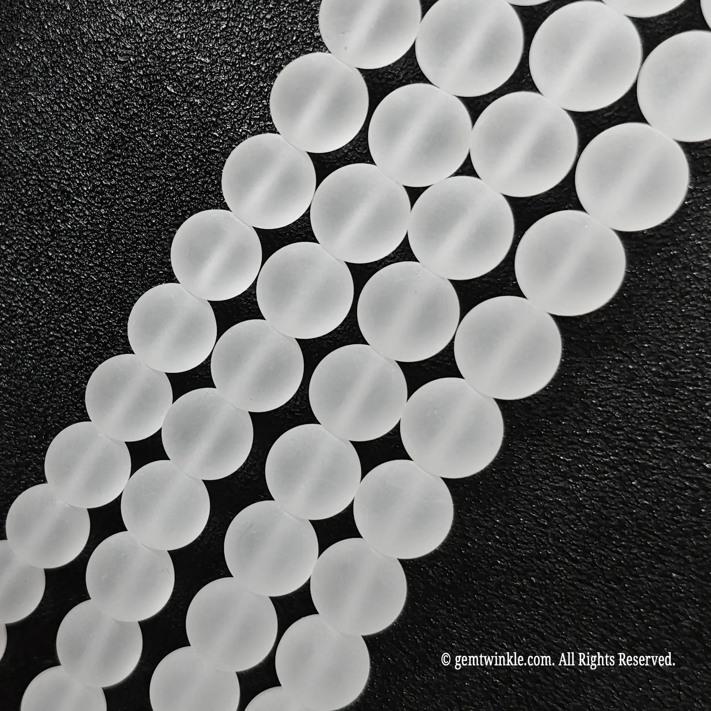 Close up view of natural clear quartz crystal beads displaying uniform velvet matte surface finish