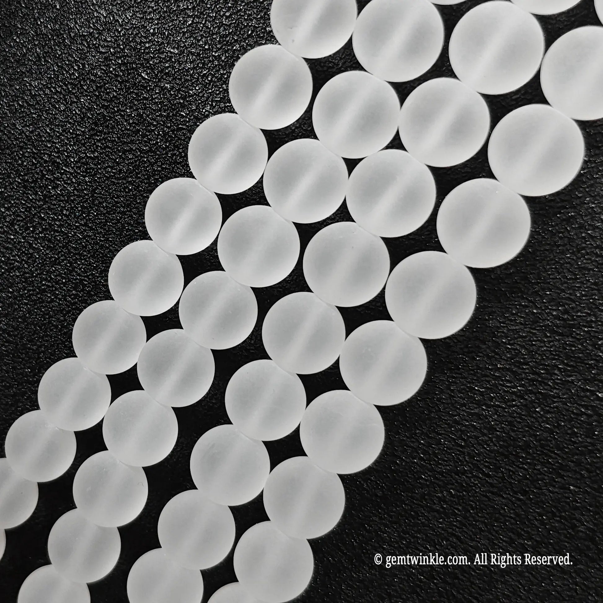 Close up view of natural clear quartz crystal beads displaying uniform velvet matte surface finish