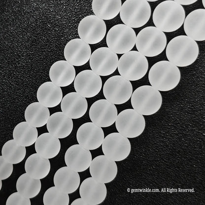 Close up view of natural clear quartz crystal beads displaying uniform velvet matte surface finish