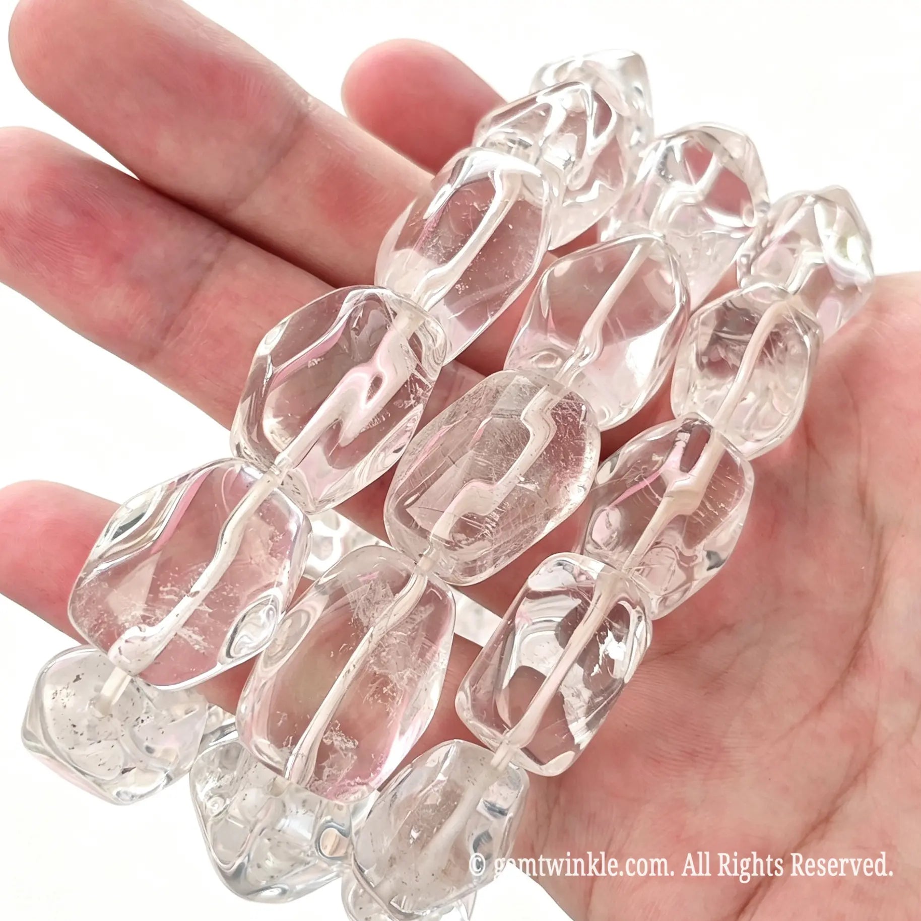 Handheld angle view of chunky clear quartz freeform bead stretch bracelets showing smooth polish and rich internal ice fissures