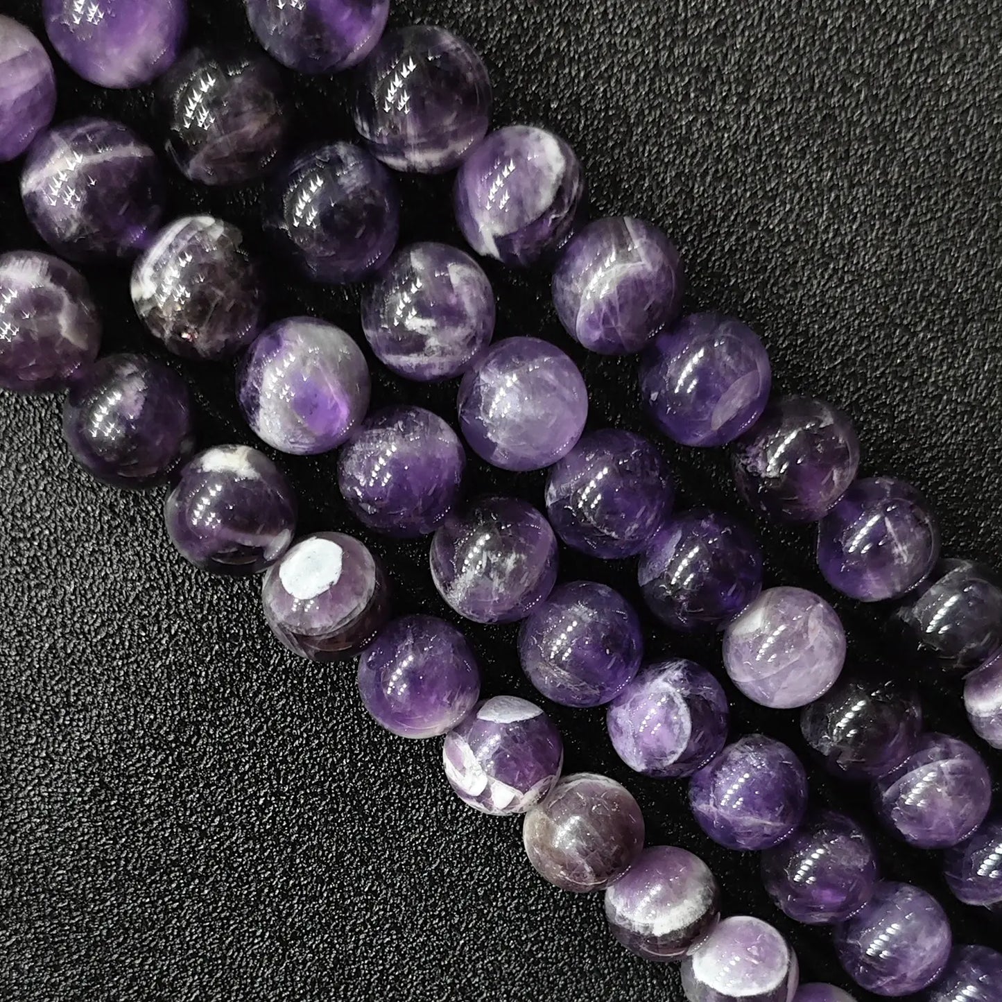 Macro detailed shot of natural dream amethyst loose round beads fresh batch with vivid contrast and zero yellowing tint