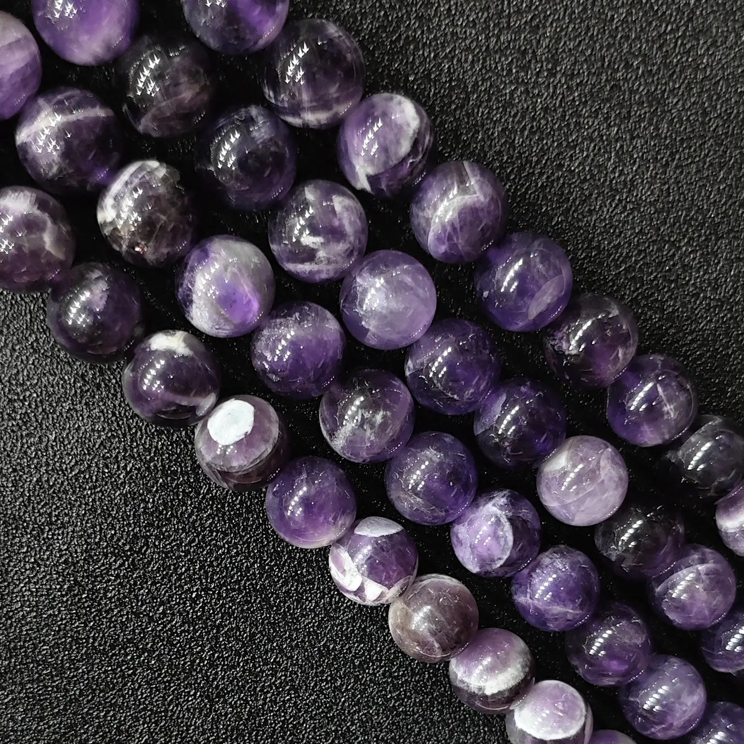 Macro detailed shot of natural dream amethyst loose round beads fresh batch with vivid contrast and zero yellowing tint