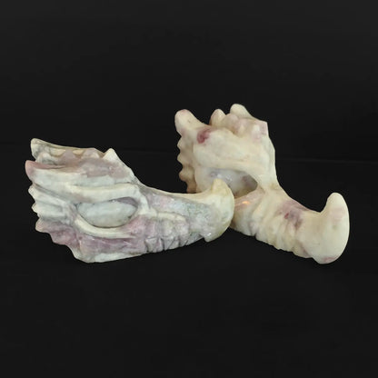 Pair of natural flower tourmaline dragon head carvings showcasing intricate mineral textures on black background
