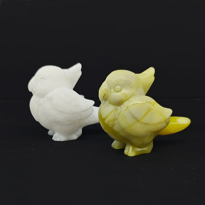 Front view of two natural gemstone cockatiel statues showing white marble and yellow green serpentine stone material variations