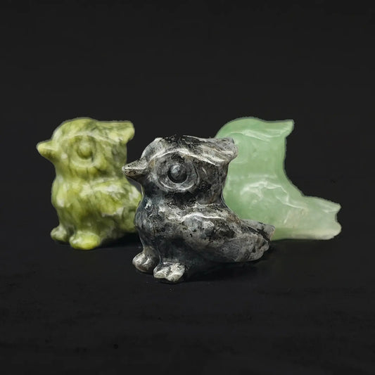 Front view of three natural gemstone tiny owl statues showing green serpentine stone spotted grey stone and green aventurine material variations