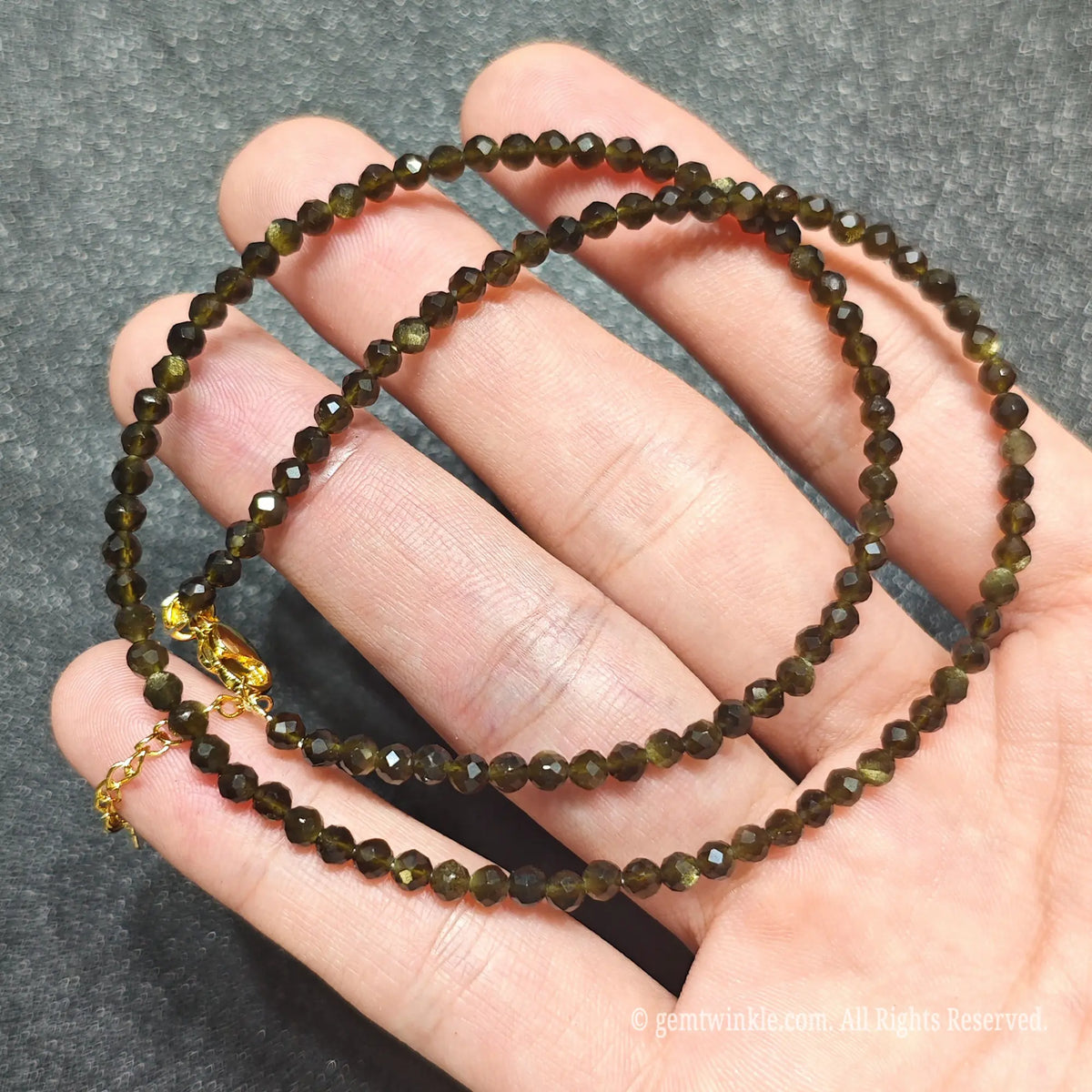 Detailed macro view of 3mm micro faceted Gold Sheen Obsidian beads showing black volcanic glass with golden shimmer