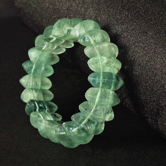Natural green fluorite chunky plate cuff bracelet showcasing translucent carved tubes on dark textured background