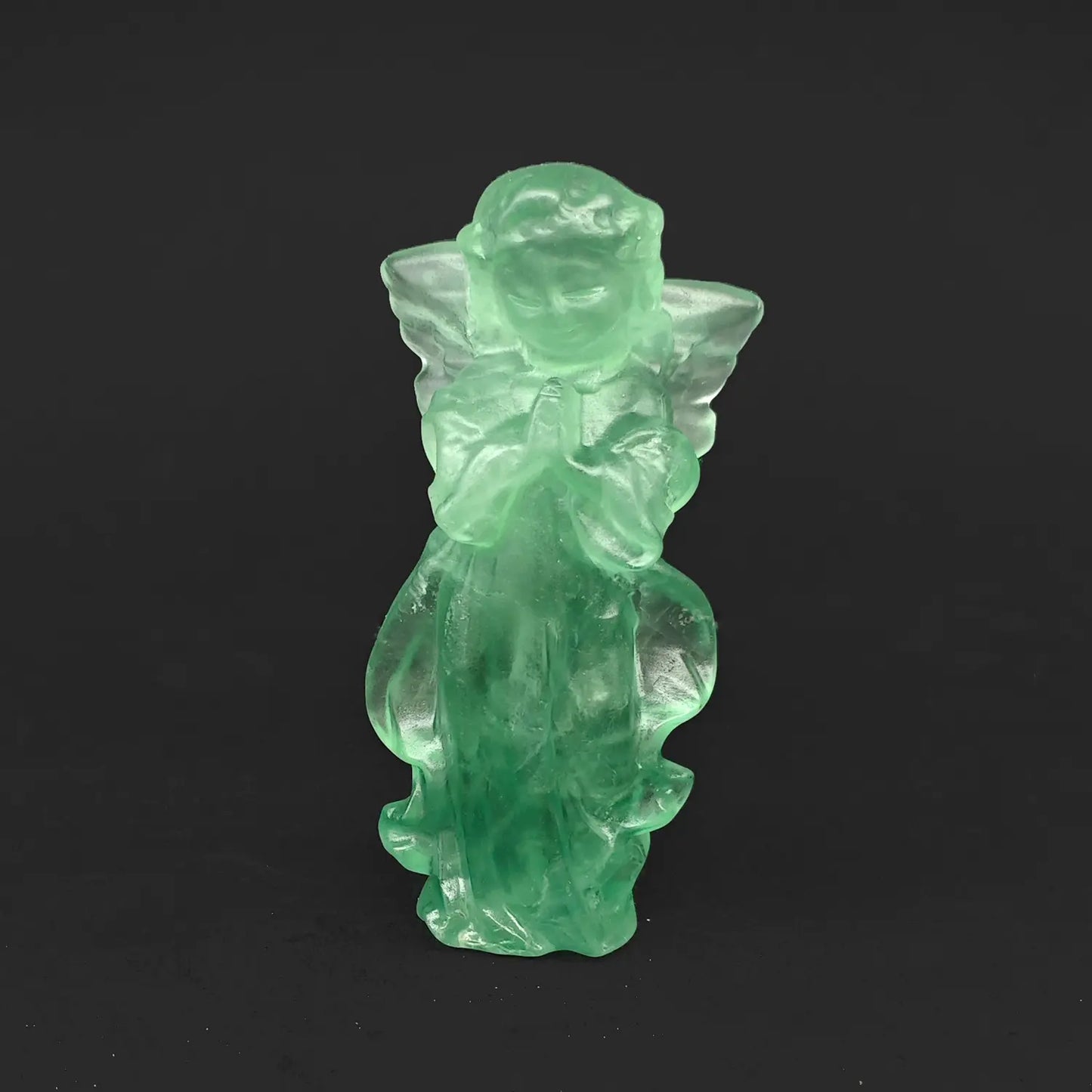 A 10cm hand-carved natural green fluorite praying guardian angel figurine with detailed wings on a dark background, ideal as unique crystal gifts for her