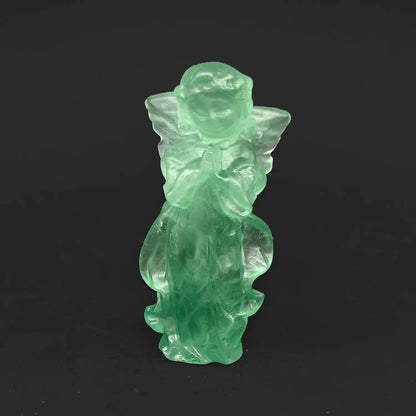 A 10cm hand-carved natural green fluorite praying guardian angel figurine with detailed wings on a dark background, ideal as unique crystal gifts for her