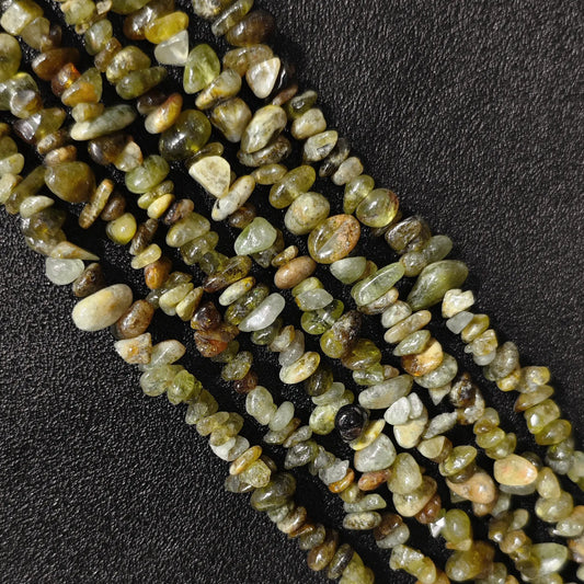 Macro closeup of natural green garnet irregular chip beads showing earthy green tones