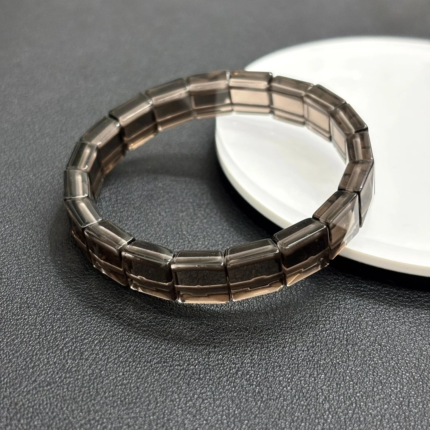 Gem's Twinkle natural icy obsidian bangle bracelet featuring rectangular beads on a white plate.
