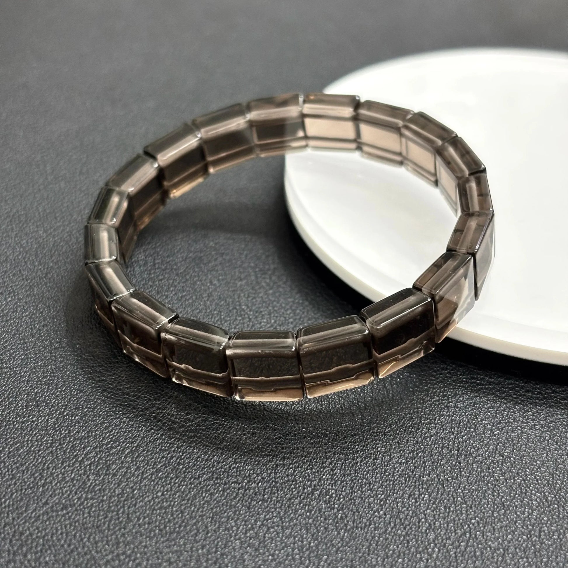 Gem's Twinkle natural icy obsidian bangle bracelet featuring rectangular beads on a white plate.
