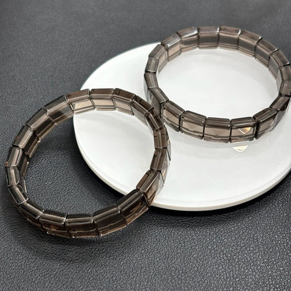 Two icy black obsidian bangles from Gem's Twinkle displayed side by side showcasing the translucent beads.