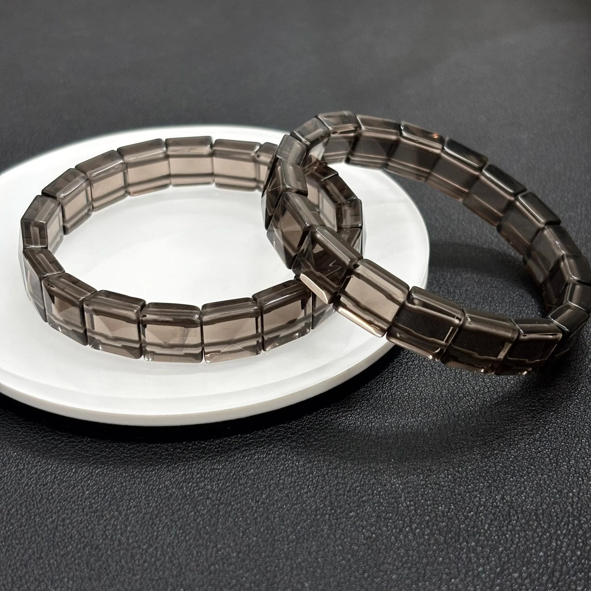 Side view of two Gem's Twinkle icy obsidian bangles highlighting the 12x10mm rectangular bead shape.