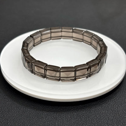 Front view of a natural icy obsidian bangle bracelet by Gem's Twinkle on a dark background.