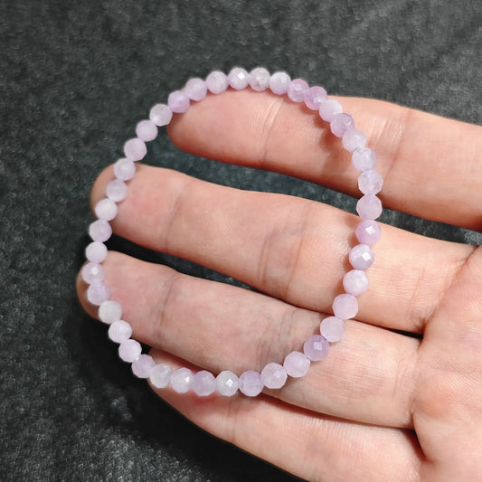 Natural Kunzite faceted mini bead bracelet held in hand showing soft lavender pink tones and fine sparkling facets