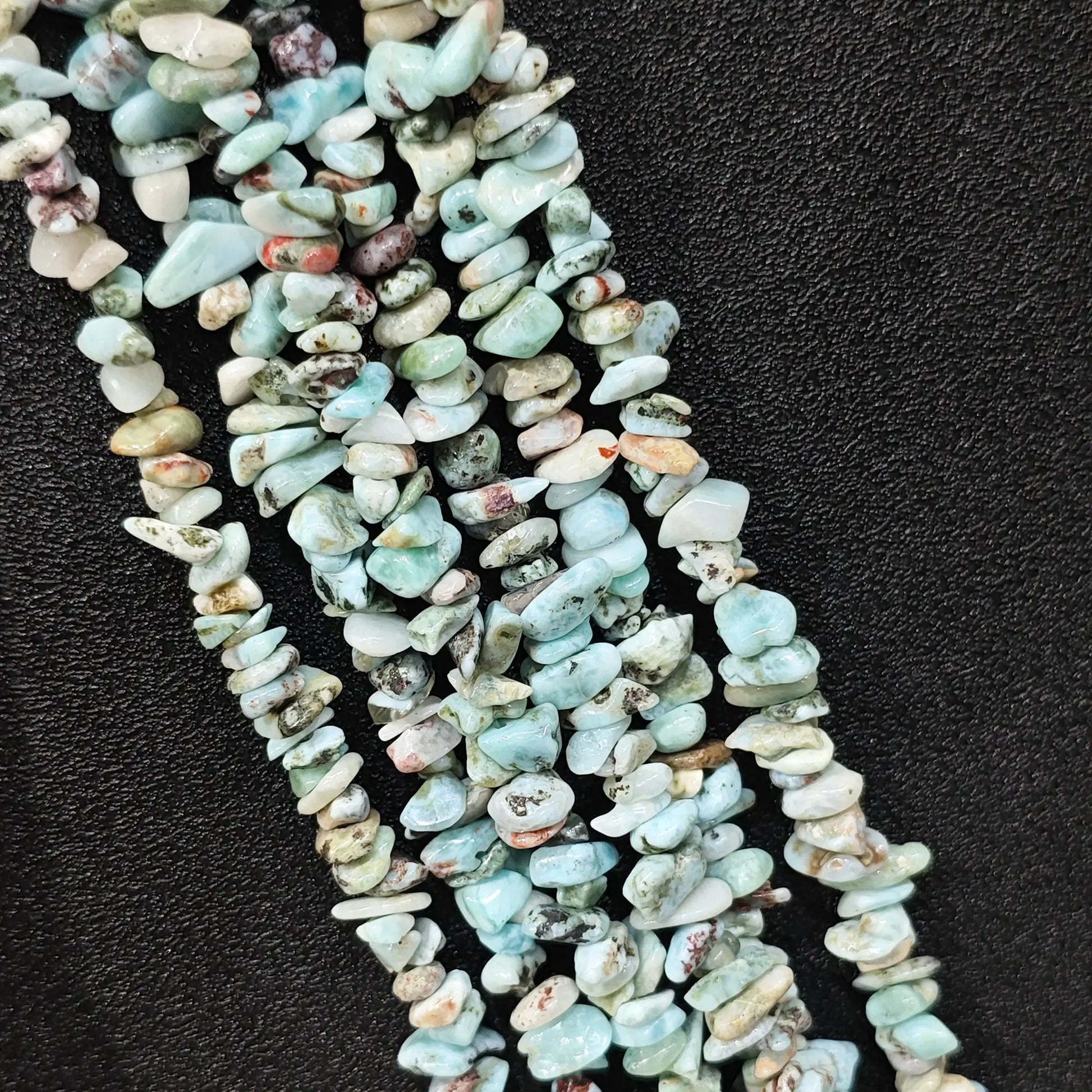 Strand of natural blue larimar freeform chip beads with host rock matrix inclusions