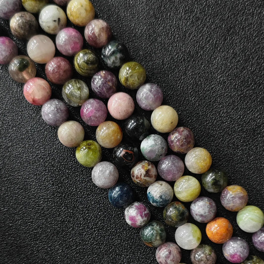 Natural multi color tourmaline gemstone round beads macro close up showing pink green yellow tones