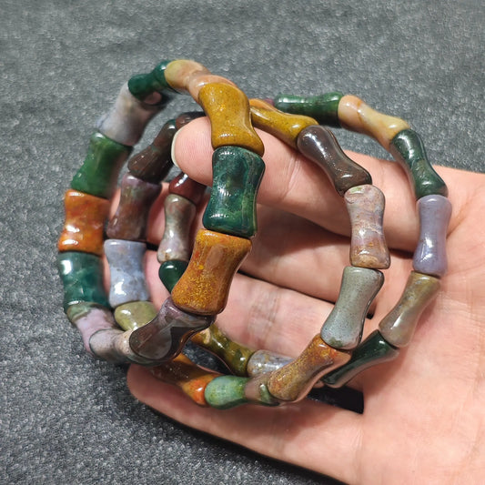 natural ocean jasper bamboo joint bracelet stacked on hand showing carved green yellow and lavender cylinder beads