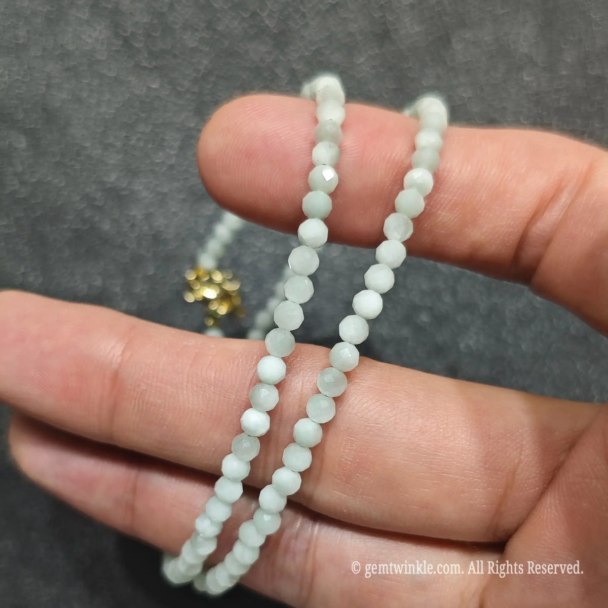 Detailed macro view of 3mm micro faceted green angelite beads showing opaque pale green mineral texture