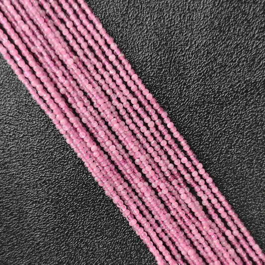Natural pink tourmaline 2mm micro seed beads close up view showing rich polished texture