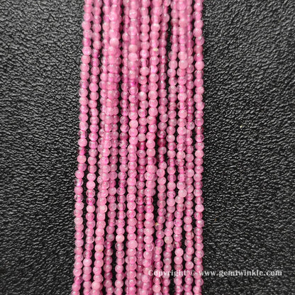 Vertical view of natural pink tourmaline micro round bead strands displaying vivid pink color