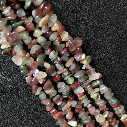 Macro closeup of natural purple and green agate irregular chip beads showing soft lavender and olive tones