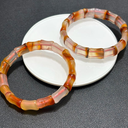 Two Natural Red Agate Bangle Bracelets displayed on a white plate, highlighting the matching bamboo bead design and earthy tones.