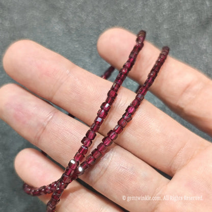 Detailed macro view of 3mm square cube Red Garnet beads showing translucent crimson gemstones