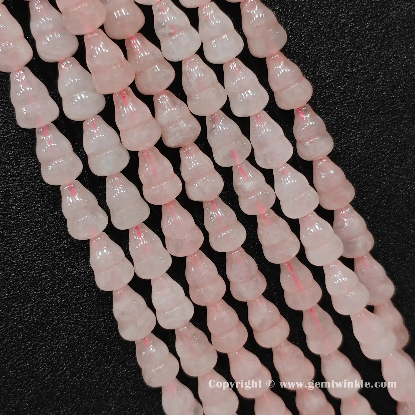 Natural rose quartz gourd bead strand held over hand showing size scale