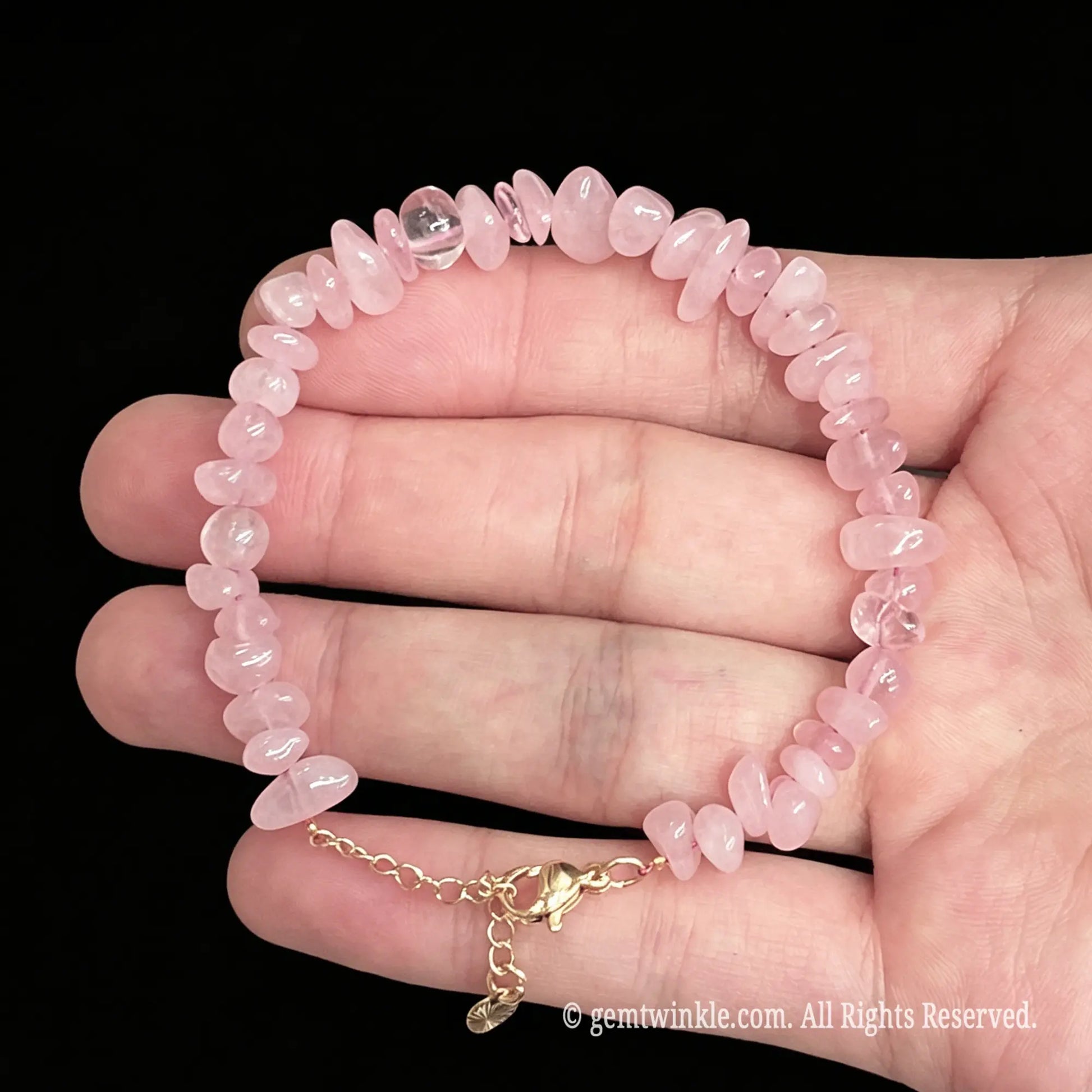 natural rose quartz raw nugget bracelet laid across palm showing soft translucent tone