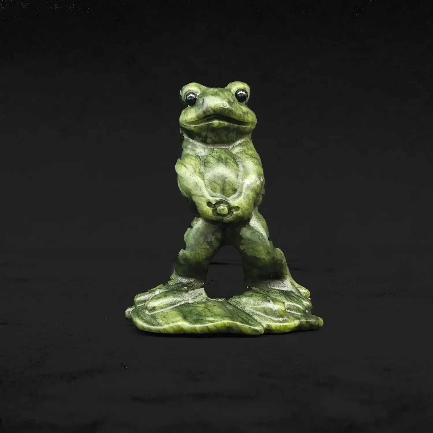 Front view of a natural serpentine peeing frog statue displaying a funny wide eyed toad standing upright in a hilarious pose