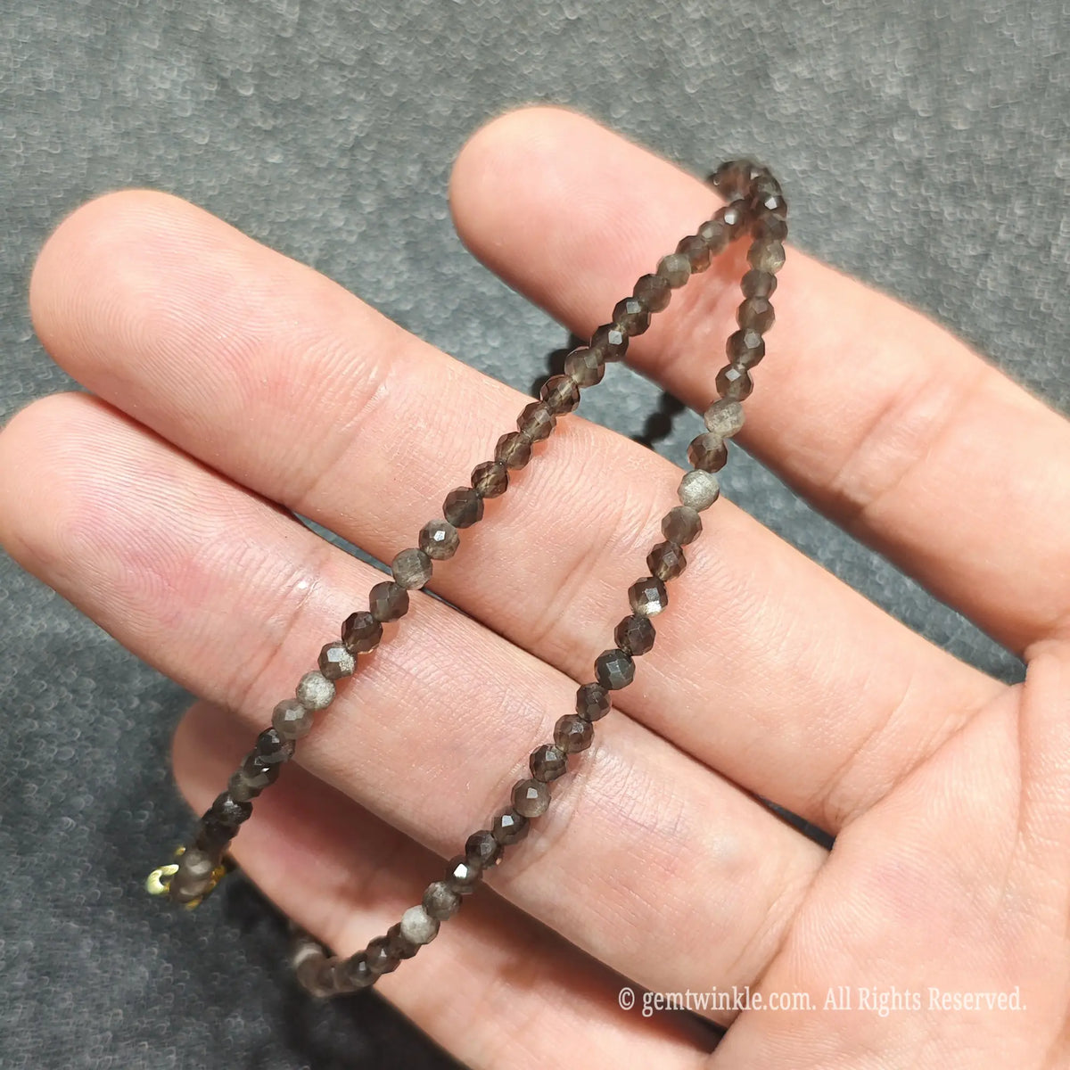 Detailed macro view of 3mm micro faceted Silver Sheen Obsidian beads showing dark volcanic glass with silver sheen