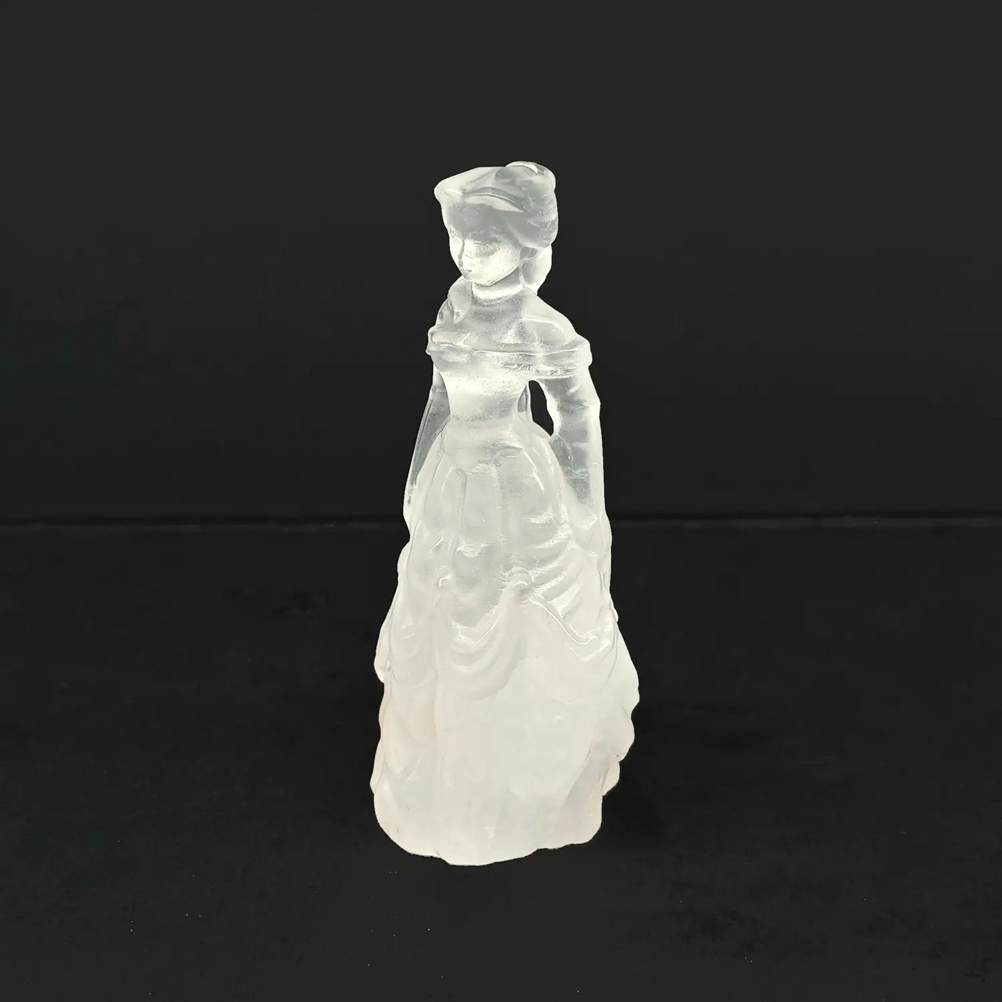 A 4-inch hand-carved natural snow quartz princess statue featuring an opaque milky white tiered ball gown on a dark background
