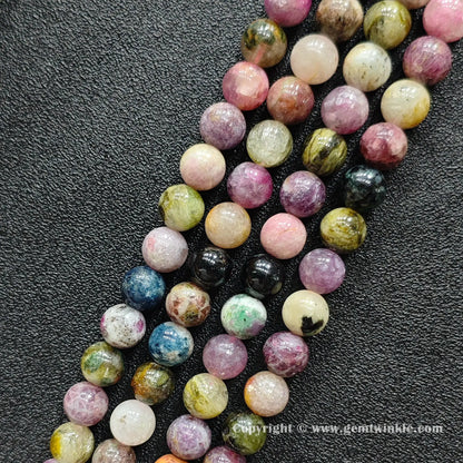 Close up detail of natural Grade C tourmaline round beads with organic mineral texture