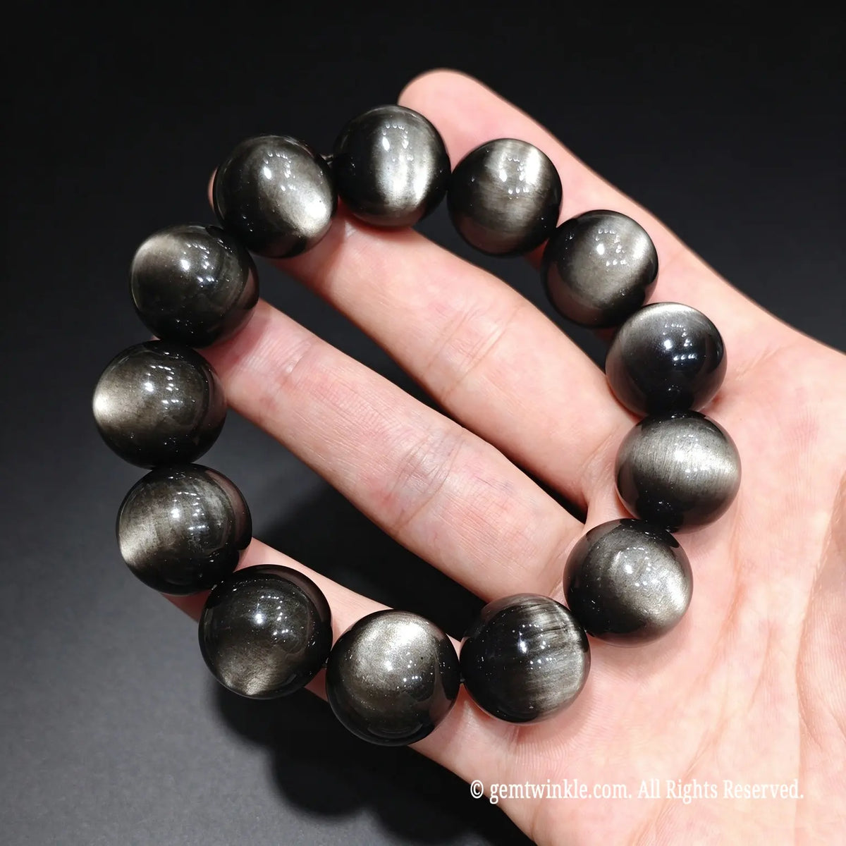 Close up view of premium quality volcanic glass silver obsidian beads highlighting mirror polish and clarity