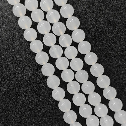 Natural milky white agate smooth round beads bulk strands showing soft glossy finish on dark background