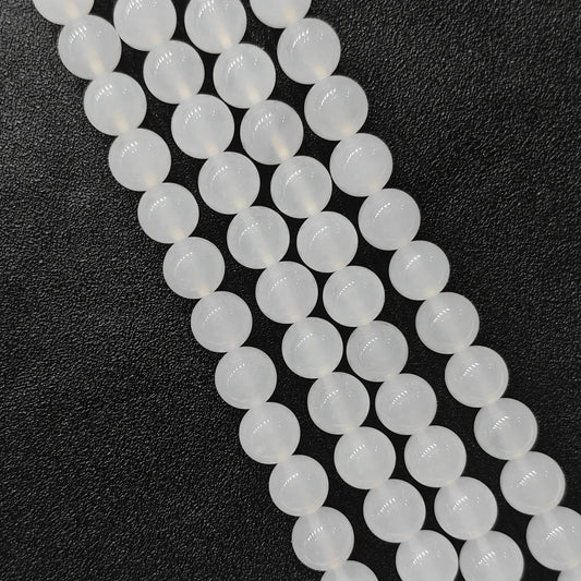 Natural milky white agate smooth round beads bulk strands showing soft glossy finish on dark background