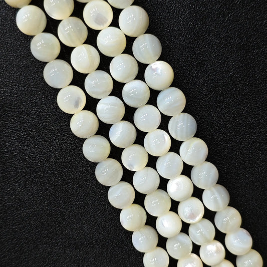 Natural white mother of pearl shell round beads showing smooth iridescent luster macro shot