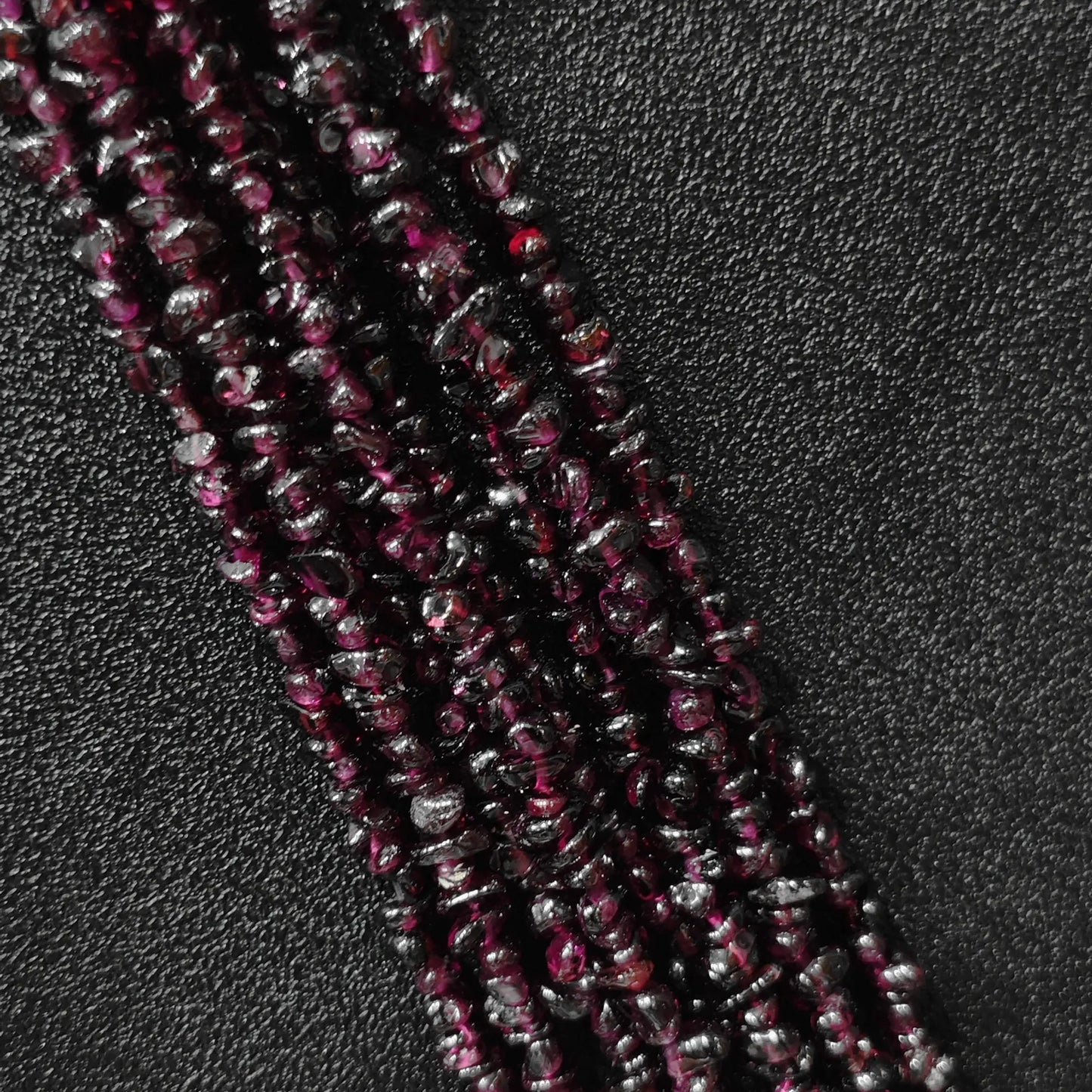Macro closeup of natural wine red garnet freeform chip beads showing deep red tones